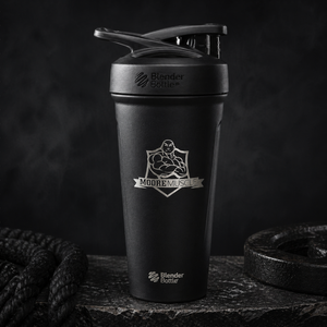 MooreMuscle black stainless steel shaker bottle with flip lid in gym setting