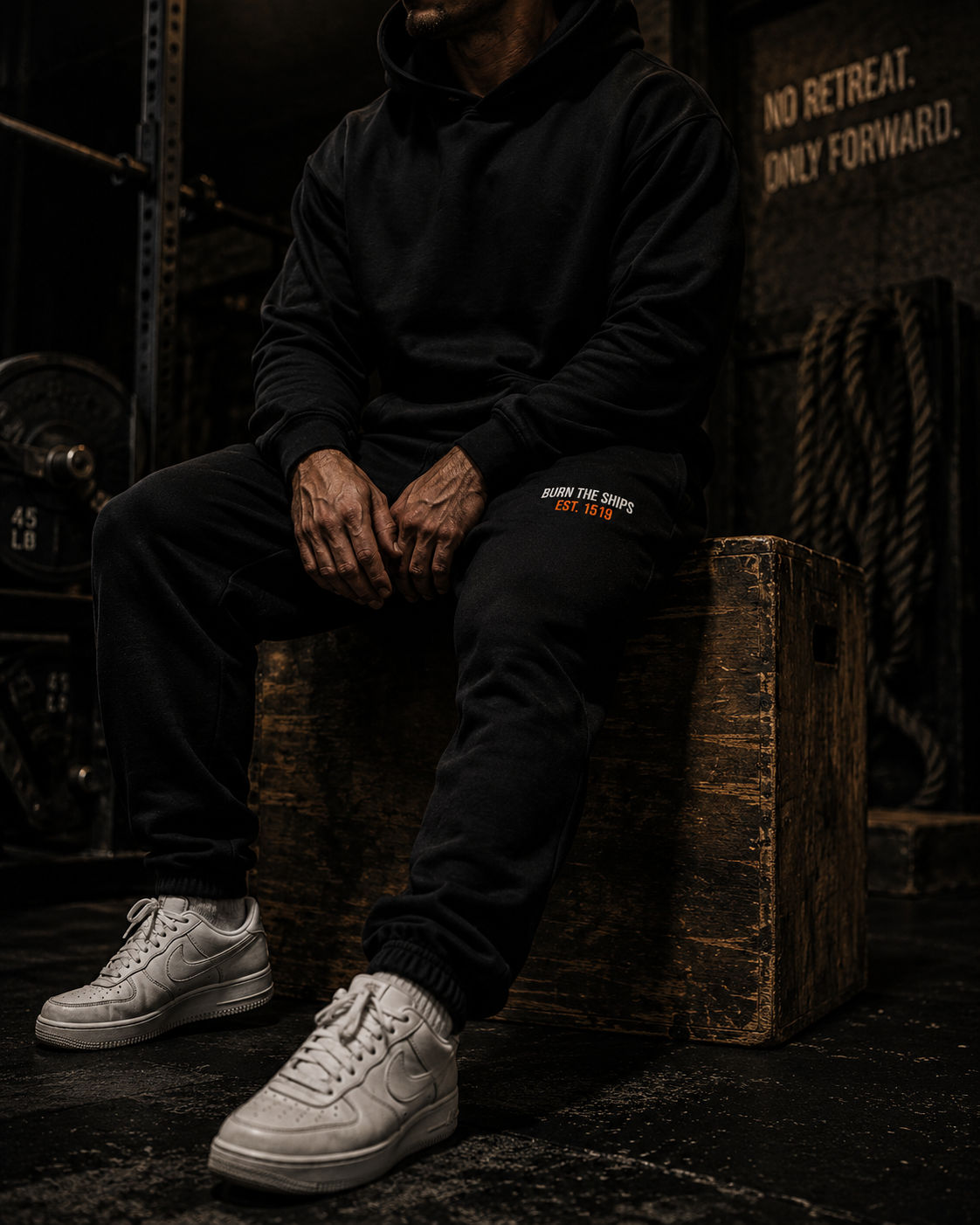 Burn The Ships heavyweight sweatpants styled in a rugged industrial environment, showcasing premium fleece construction and relaxed fit.
