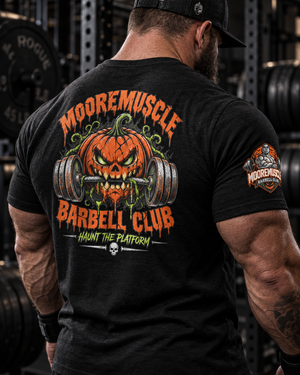 Close-up of the MMBC Halloween Tee 2026 back print and sleeve crest showing the MooreMuscle Barbell Club pumpkin skull graphic