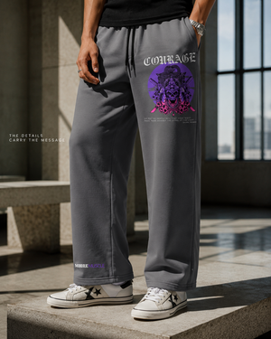 Close-up of gray MooreMuscle Courage wide-leg sweatpants featuring purple thigh artwork and lower-leg logo.
