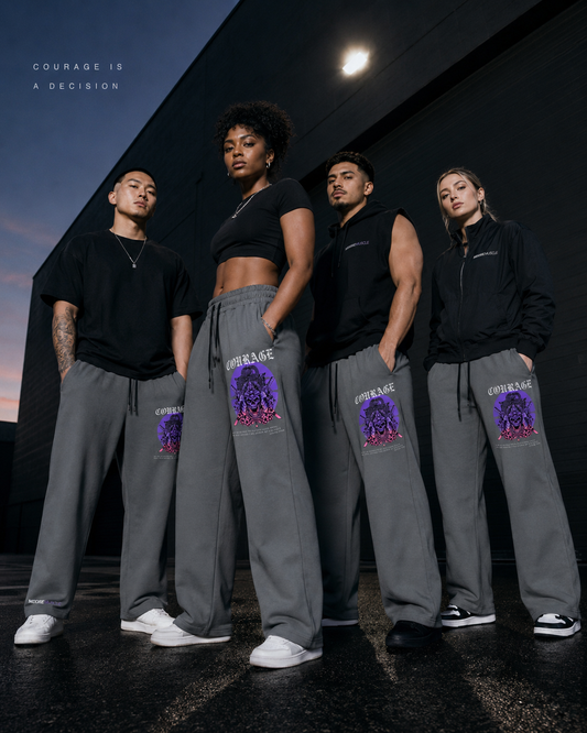 Diverse athletes wearing gray MooreMuscle Courage wide-leg sweatpants in a modern streetwear campaign at dusk.