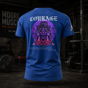 Courage Collection tri-blend t-shirt in royal blue featuring a large samurai skull back graphic in purple and pink, photographed inside a powerlifting gym with squat racks, barbells, and competition plates in the background.