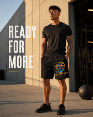 Male athlete wearing black MooreMuscle Legendary performance shorts outside a modern gym at golden hour.