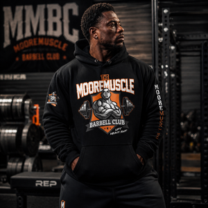 Male athlete wearing MooreMuscle Barbell Club Hoodie in gym showcasing premium fit and strength lifestyle