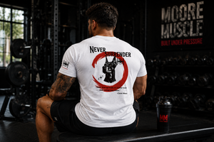 Male athlete seated on a gym bench wearing the white Never Surrender tee with the back graphic visible.