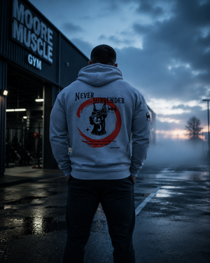 Never Surrender zip hoodie worn outside a gym at sunrise featuring the Doberman back graphic.