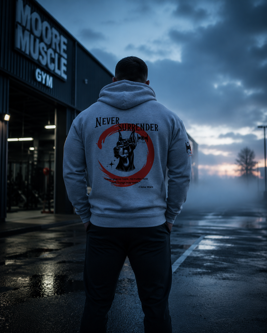 Never Surrender zip hoodie worn outside a gym at sunrise featuring the Doberman back graphic.