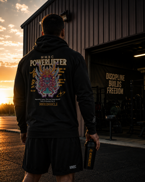 Athlete wearing MooreMuscle MMBC Powerlifter t-shirt hoodie outside a strength gym at sunset