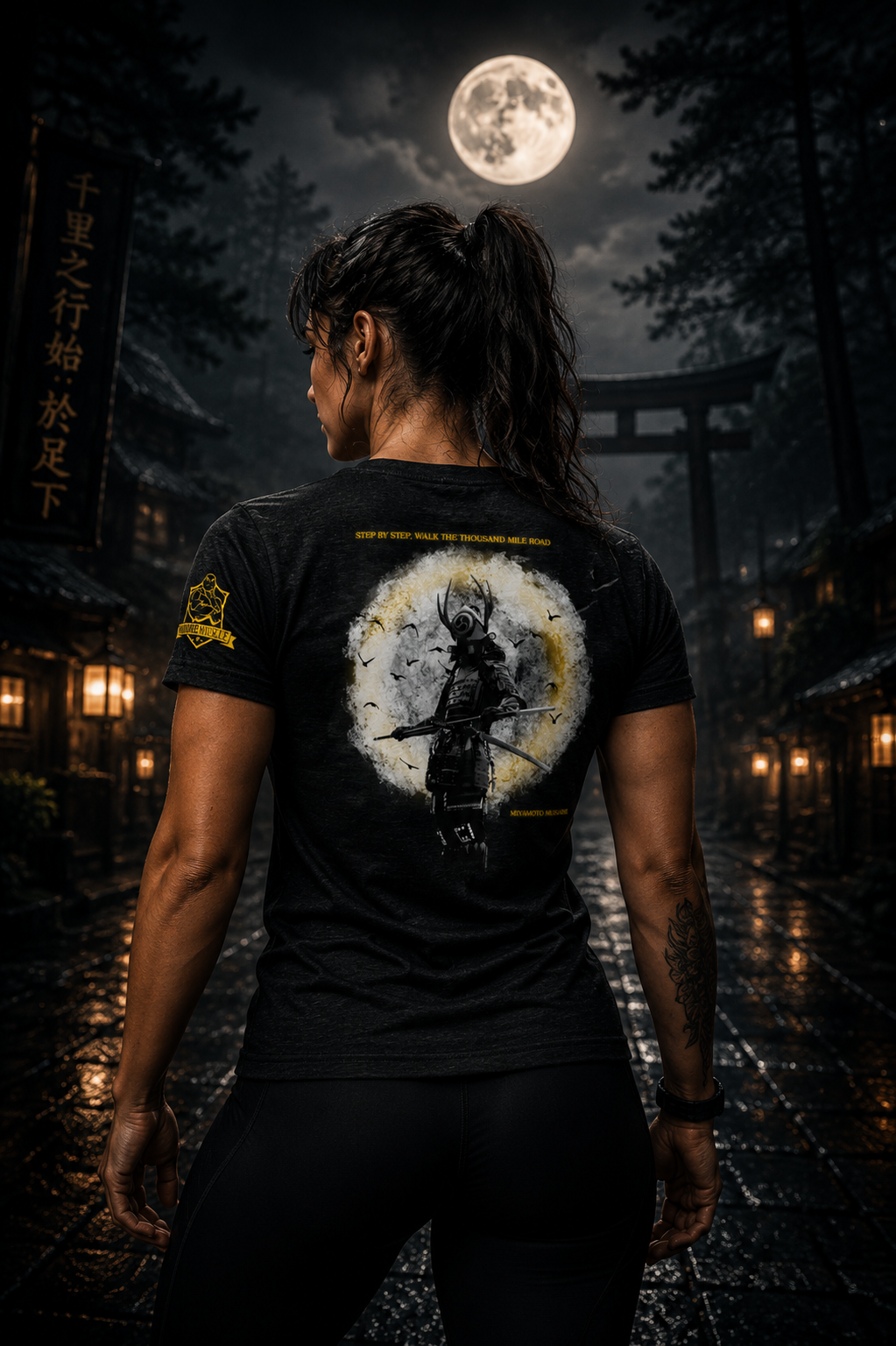 Person wearing a black t-shirt with a graphic design, standing in a mystical setting with a full moon and torii gate.