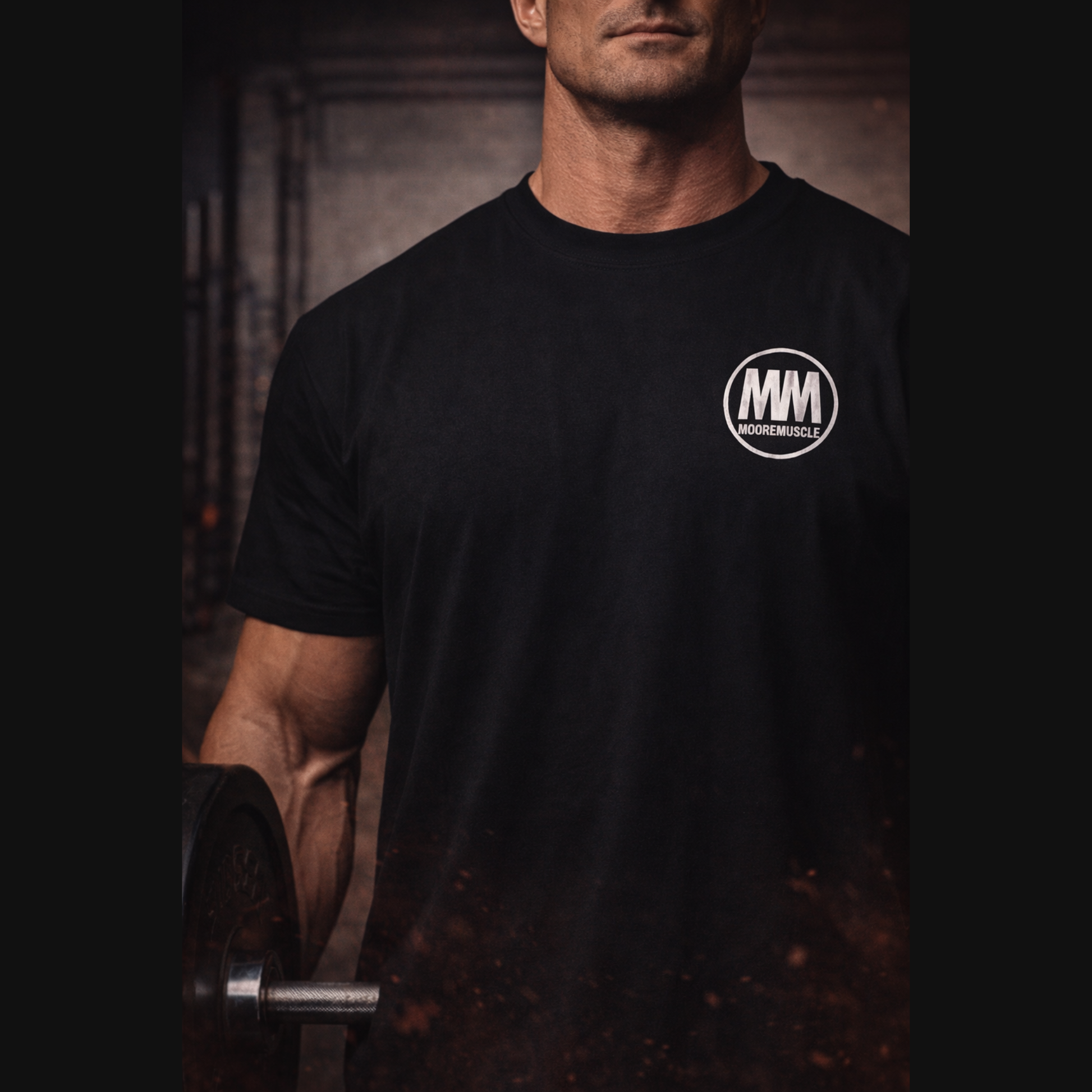MooreMuscle black heavyweight t-shirt with white MM embroidered chest logo worn in gym holding barbell