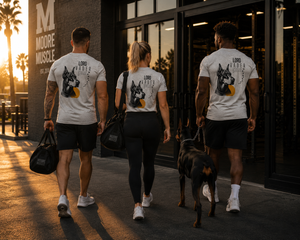 Group of athletes wearing Lord Vader memorial apparel walking toward the gym with a Doberman.