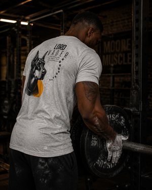Athlete loading plates onto a barbell while wearing the Lord Vader memorial tri-blend tee.