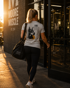Female athlete wearing the Lord Vader memorial tee while walking into the gym at sunrise.