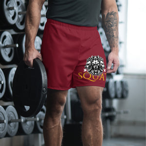 Athlete wearing maroon SQUAT shorts in gym holding plates, SQUAT graphic visible.