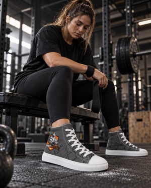 Woman sitting on a weight bench in grey MooreMuscle Crest high top sneakers with white laces and soles