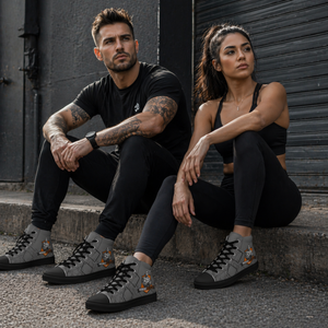 Male and female athletes wearing MooreMuscle grey high top sneakers with black soles sitting on a curb in an urban industrial setting showcasing lifestyle use