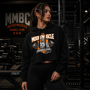 Female athlete wearing black MooreMuscle MMBC cropped hoodie in gritty gym environment front view