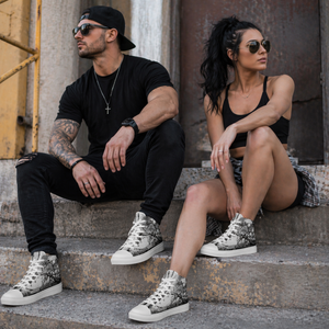 Male and female athletes wearing MooreMuscle skull design high top training shoes on industrial steps
