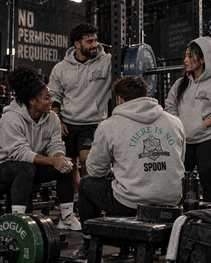 Group of lifters talking in a powerlifting gym, all wearing gray MooreMuscle There Is No Spoon hoodies