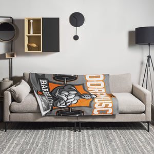 MooreMuscle Barbell Club throw blanket displayed on living room couch