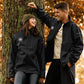 Man and woman wearing black MooreMuscle soft shell jackets outdoors during fall, showcasing everyday lifestyle wear.
