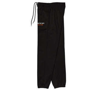 Side view of Burn The Ships heavyweight black sweatpants with elastic cuffs, interior drawcord, side pockets, and embroidered thigh detail.